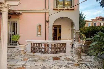 a pink house with a porch and a balcony at Parcheggio Privato - Villa Liberty Roma Centro in Rome