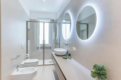 a white bathroom with a sink and a mirror at DOMUS LUX ANGELICA- Nearby Vatican in Rome