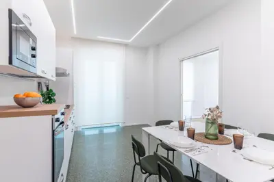 a kitchen and dining room with a white table and chairs at DOMUS LUX ANGELICA- Nearby Vatican in Rome