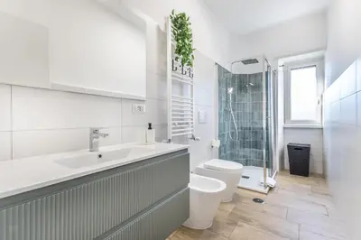 a white bathroom with a sink and a toilet at Green House Marconi in Rome