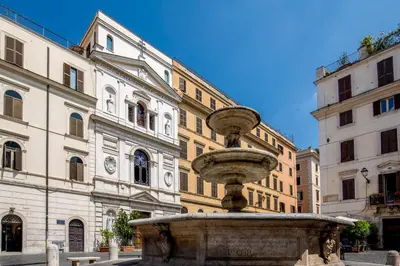 a fountain in the middle of a street with buildings at Empire Loft in the shadow of Colosseum in Rome