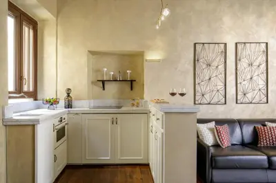 a kitchen with a counter and a couch in a room at Spanish Steps Boutique Apartment in Rome
