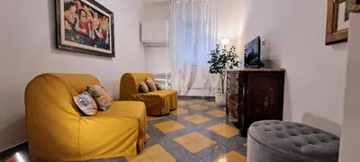 a living room with two yellow chairs and a television at Machiavelli Forty Seven in Rome