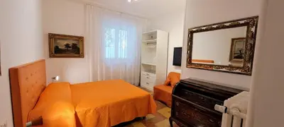 a bedroom with an orange bed and a mirror at Machiavelli Forty Seven in Rome