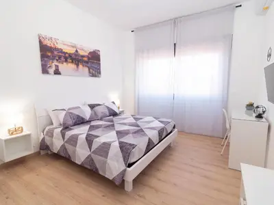 a white bedroom with a bed and a painting on the wall at Alloggio Roma San Pietro da Silvia in Rome