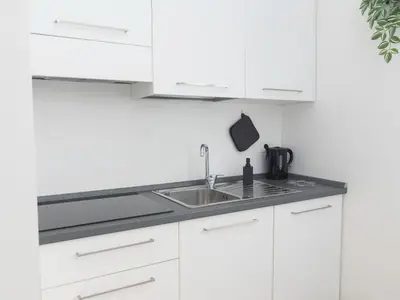 a kitchen with white cabinets and a sink at Alloggio Roma San Pietro da Silvia in Rome