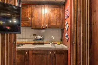 a kitchen with wooden cabinets and a sink at The Eleanor Secret Studio - Campo de' Fiori in Rome