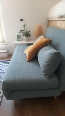 a blue couch with pillows on it in a room at Amazing studio with terrace in Rome