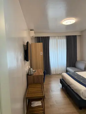 a small hotel room with a bed and a table at Vatican Bliss in Rome