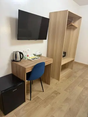 a room with a desk with a tv and a blue chair at Vatican Bliss in Rome