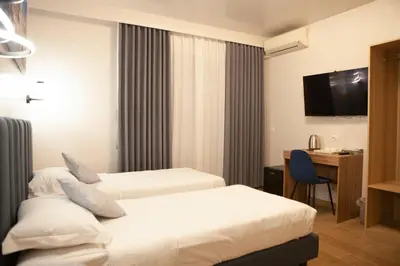 a hotel room with two beds and a desk at Vatican Bliss in Rome