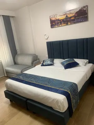 a bedroom with a large bed and a chair at Vatican Bliss in Rome