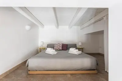 a bedroom with a large bed in a white room at Casina Bianca in Rome