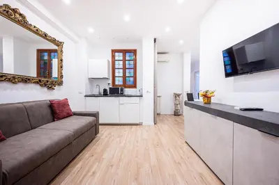 a living room with a couch and a kitchen at Anna Vatican Loft - Relax al centro di Roma! in Rome
