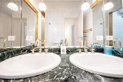 two sinks in a bathroom with two mirrors at Anna Vatican Loft - Relax al centro di Roma! in Rome
