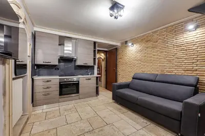 a living room with a couch and a brick wall at Oliviero - Piazza Navona Apartment in Rome
