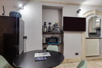 a dining room with a table and a tv at Oliviero - Piazza Navona Apartment in Rome