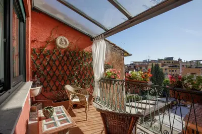 a balcony with two chairs and a fence at Tiberim Lux Penthouse City View in Rome