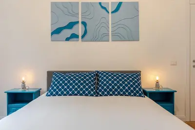 a bedroom with a bed with two blue tables at Domus Adriana Ada - adiacente metro A in Rome