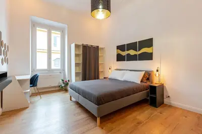 a bedroom with a bed and a desk at Domus Adriana Ada - adiacente metro A in Rome