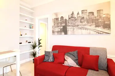 a red couch in a living room with a painting on the wall at Casa di Lola Metro Conca d' Oro in Rome