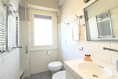 a bathroom with a sink and a toilet and a mirror at Casa di Lola Metro Conca d' Oro in Rome