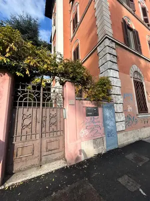 a gate with graffiti on the side of a building at Statilia Urban Retreat in Rome