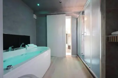 a bathroom with a tub and a glass shower at Termini Comfort Rooms and Jacuzzi Suite by Flatinrome in Rome