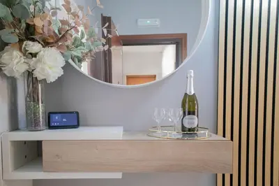 a table with a bottle of wine and a mirror at Sara's Home - Modern Apartment Near Metro, Perfect for Families and Groups in Rome in Rome