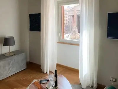 a living room with a table and a window at pantheon suite 11 in Rome