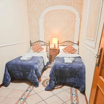 a room with two beds and a table with a lamp at Hotel Giubileo in Rome