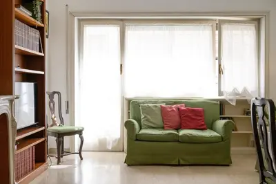 a green couch with two red pillows in a living room at Casa NeLLa, Apartment with 2 bedrooms, Rome in Rome