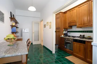 a kitchen with wooden cabinets and a green tile floor at Casa NeLLa, Apartment with 2 bedrooms, Rome in Rome