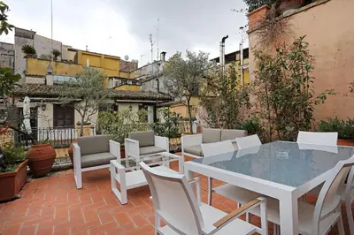 a patio with a white table and chairs at Domus Leonina - Stunning Terrace on the Roman Forum in Rome