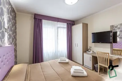 a bedroom with a bed and a desk and a tv at HOTIDAY Room Collection - Roma Barberini in Rome