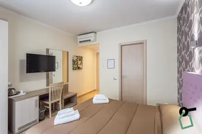 a room with a bed and a desk and a tv at HOTIDAY Room Collection - Roma Barberini in Rome