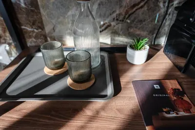 three cups on a tray on a table with a vase at Whim Collection Trastevere in Rome