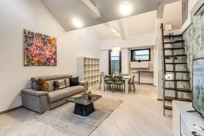 a dining room with a table and chairs and a couch at The Loft Trastevere in Rome