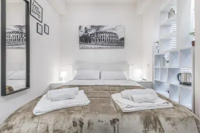 a white bedroom with a large bed with two pillows at Battistini Sweet House in Rome