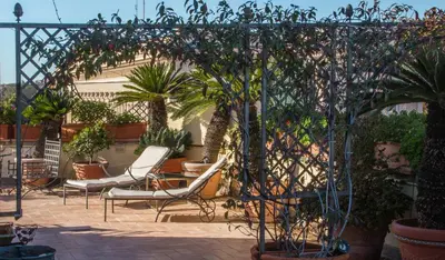a patio with chairs and potted plants at Terrazze di Venere in Rome
