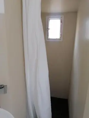 a white shower curtain in a bathroom with a window at All'angolo di San Pietro - wifi in Rome