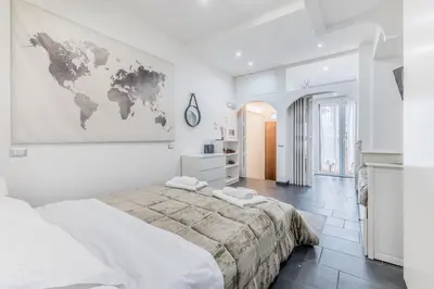 a white bedroom with a large bed and a map on the wall at Battistini Sweet Apartament in Rome