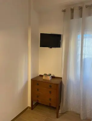 a room with a dresser and a television on a wall at Pineta Domus in Rome