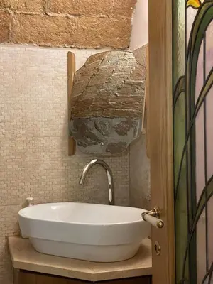 a white sink in a bathroom with a mosaic wall at Roman times experience in Monti area in Rome