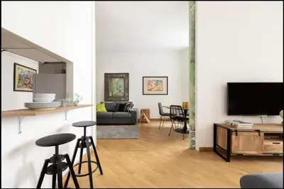 a living room with a flat screen tv and chairs at Luxury Apartment Spanish Steps in Rome