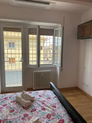 a bedroom with a bed in a room with windows at Attico con balcone in Rome