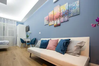 a living room with blue walls and a white couch at Appia - Regina Viarum B&B in Rome