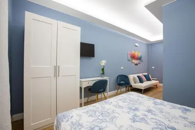 a bedroom with blue walls and a bed and a desk at Appia - Regina Viarum B&B in Rome