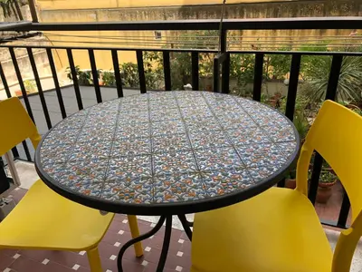 a table with yellow chairs on a balcony at Casa Salù in Rome