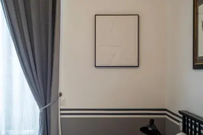 a picture hanging on a wall next to a window at Castro Pretorio 24 - FromHometoRome in Rome